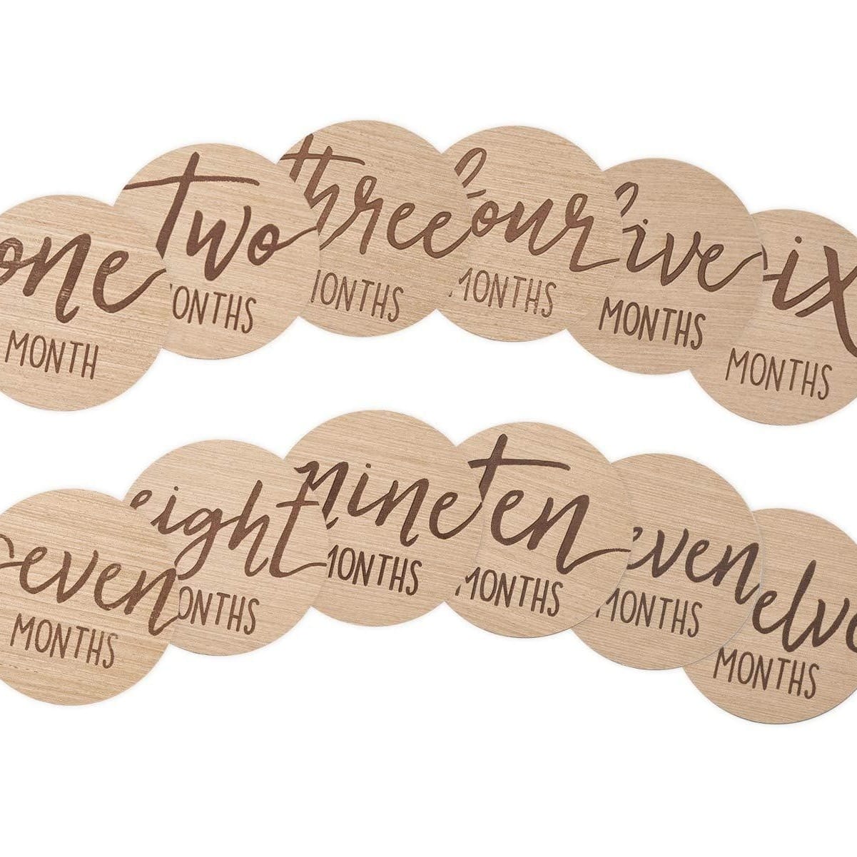 Wooden milestone discs double as Baby Growth Month Cards, each labeled with numbers one through twelve and the word "months" in script and printed text.