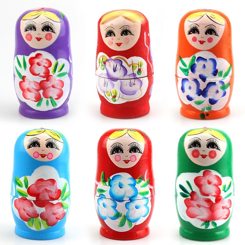 Six colorful wooden Russian nesting dolls, each painted with floral patterns and smiling faces, arranged in two rows of three against a white background—a charming example of traditional wooden giftware.