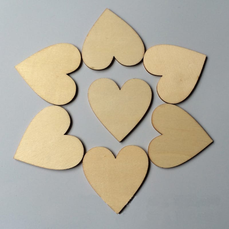 Seven wooden hearts arranged in a circular, flower-like pattern on a plain gray background.