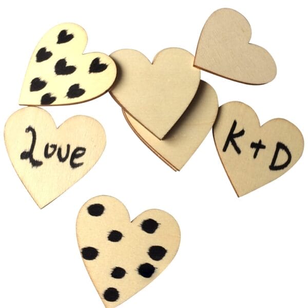 Seven hand-painted wooden heart cutouts, some with black spots, one inscribed with "Love" and another with "K+D," displayed on a white background—perfect for craft projects or as a wholesale supplier’s charming addition.
