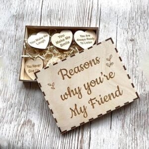 Wooden gift box with engraved "Reasons why you're my friend" and small wood hearts inscribed with heartfelt messages. Unique friendship gift.