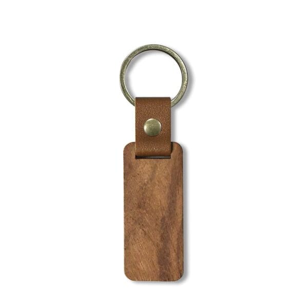 A rectangular wooden keychain with a brass keyring and brown leather strap attached by a metal rivet, shown on a white background—perfect for those seeking custom laser-cut wooden keychains.