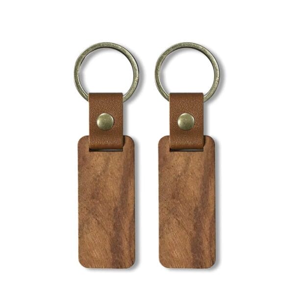 Two rectangular custom wooden keychains with brown leather straps and metal rings, displayed side by side on a white background.