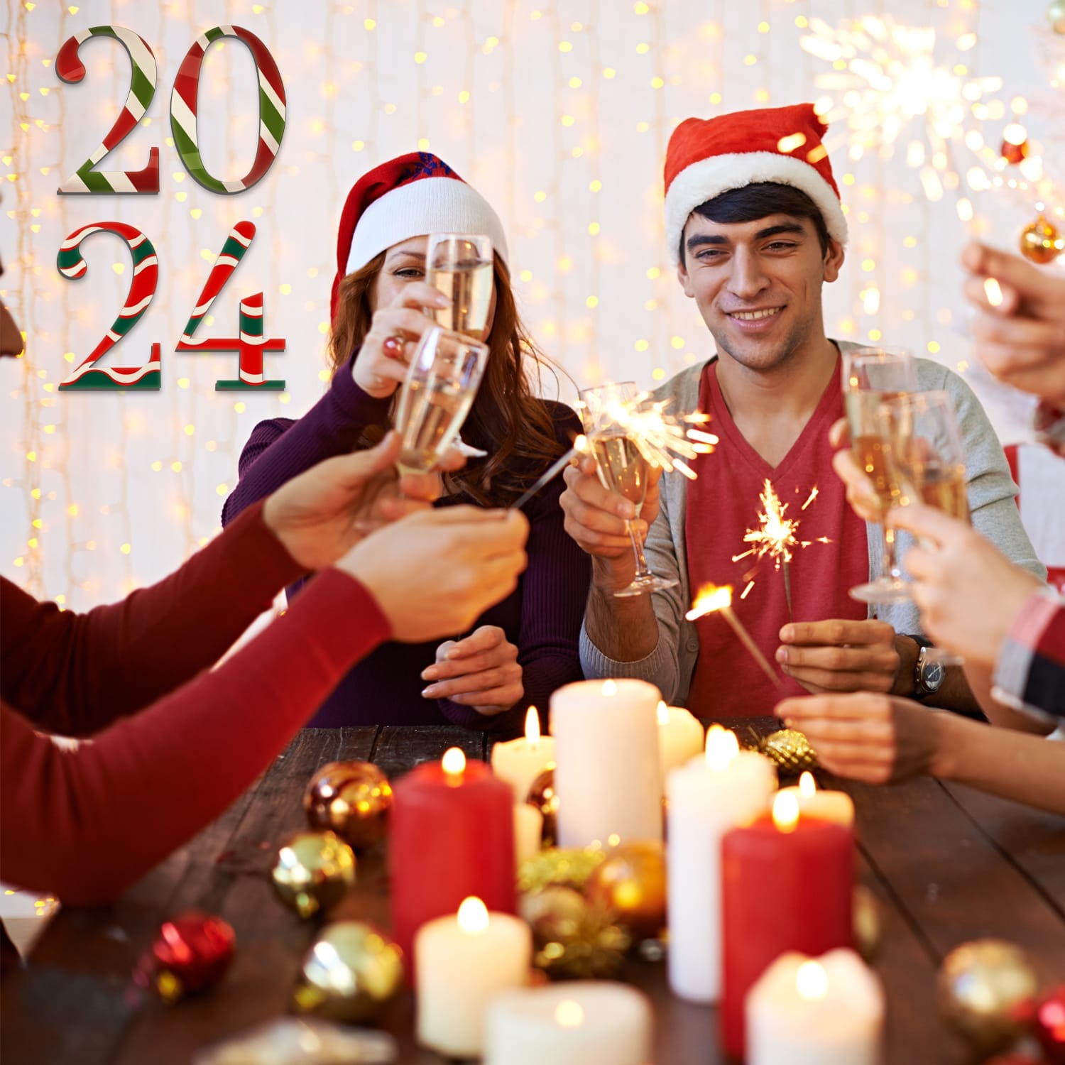 People in Santa hats clink glasses and hold sparklers around a decorated table with candles, ornaments, and Wooden Craft Letters that spell “2024” in festive text as creative wall decor.
