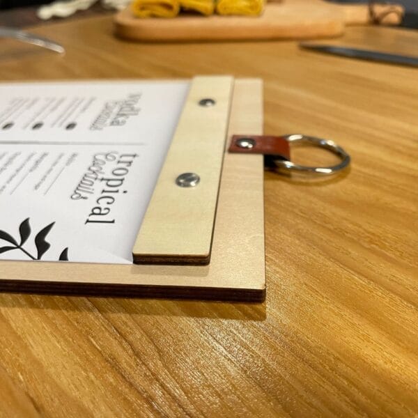 Wooden menu board with replaceable inserts, showing "Tropical Cocktails" menu. Eco-friendly design.