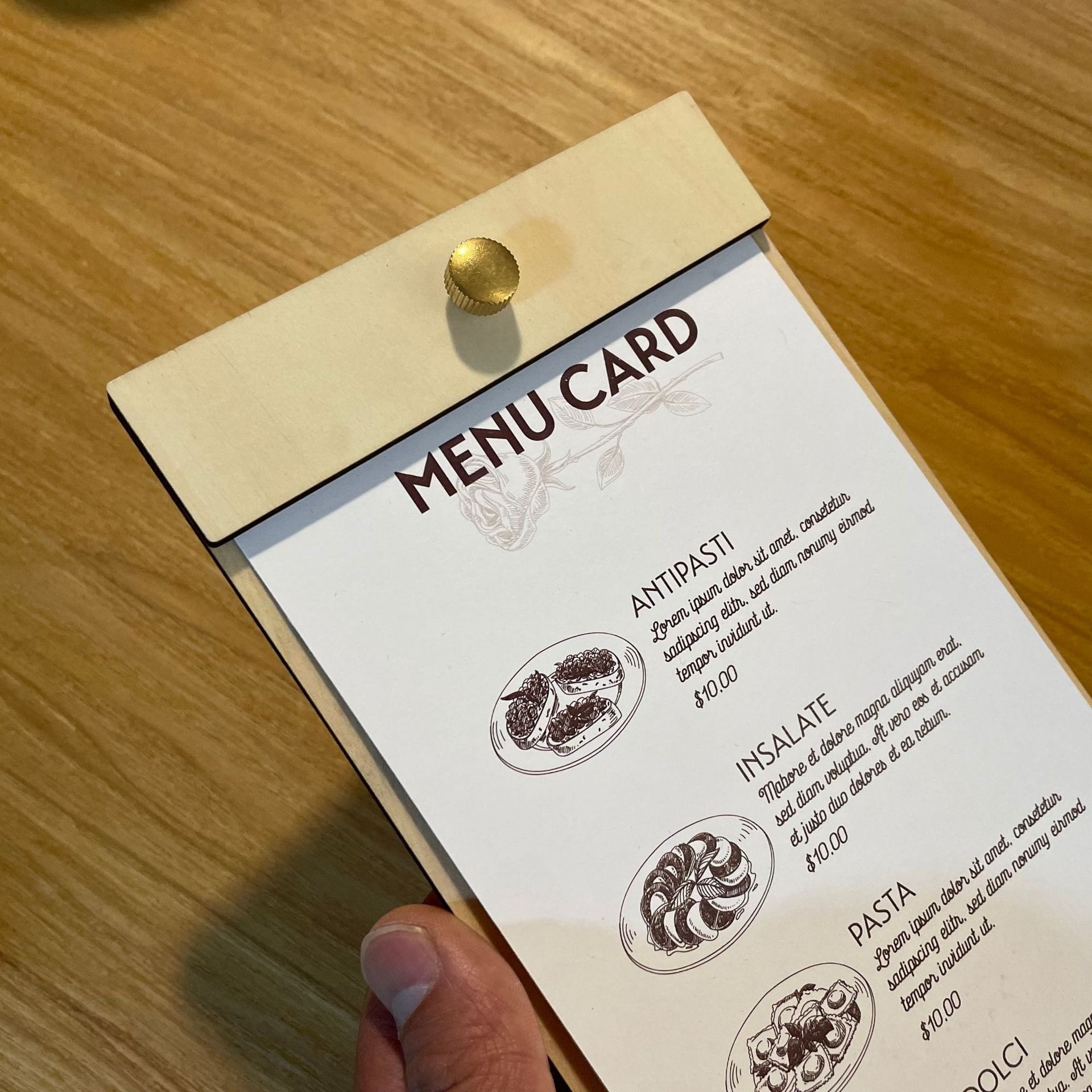Wooden menu card with replaceable inserts, showing "Antipasti," "Insalate," and "Pasta" options.