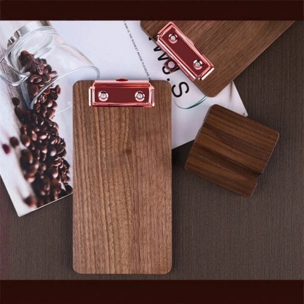 Rose gold clipboard and wooden stand on dark desk