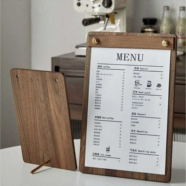 Freestanding solid walnut menu holder with brass accents displaying a restaurant menu.