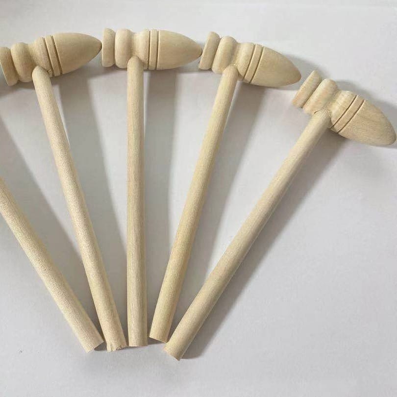Five small, unfinished mini wooden hammer toys are arranged in a fan shape on a white background—perfect for wholesale or pairing with wooden sticks crafts.