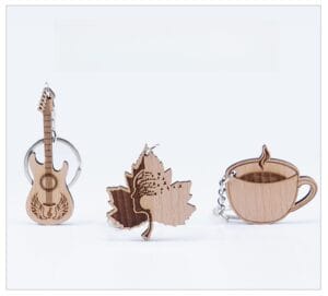 Personalised wooden keychain set: guitar, leaf, and coffee cup laser-engraved designs with metal rings.