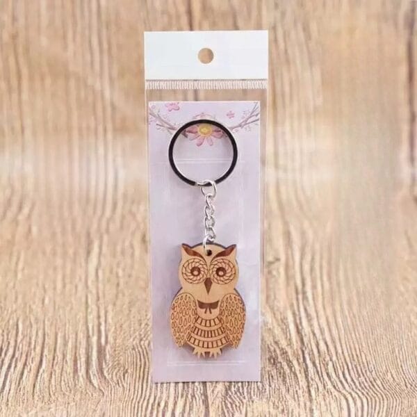Personalised wooden keychain featuring a laser-engraved owl design with metal ring, packaged for gifting.