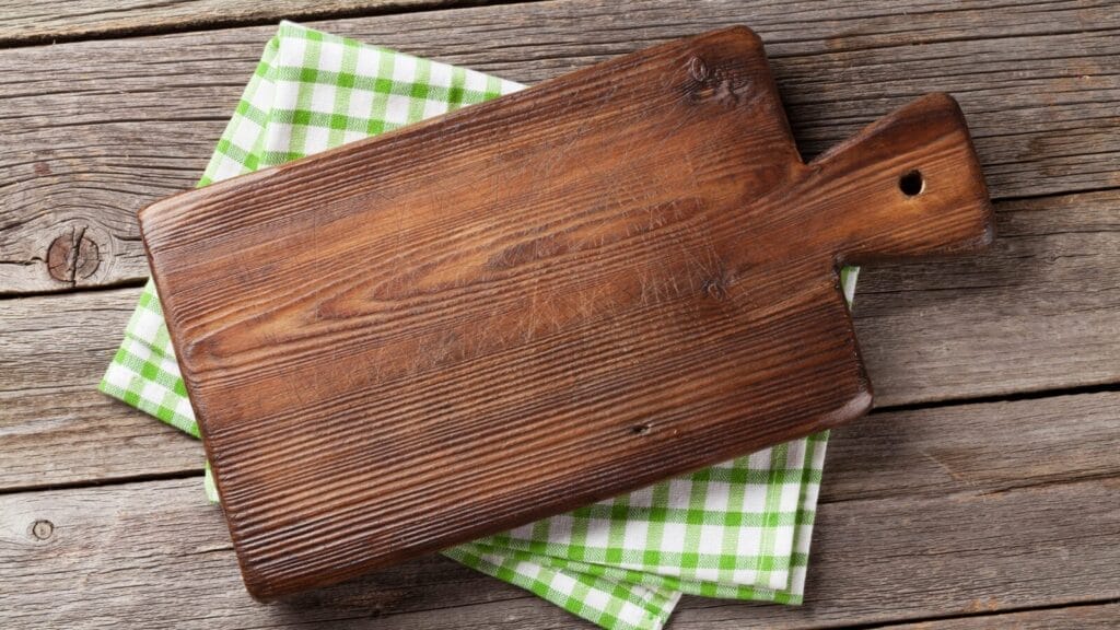 Rustic wooden cutting board on a green checkered cloth. Safe home sanitizing.