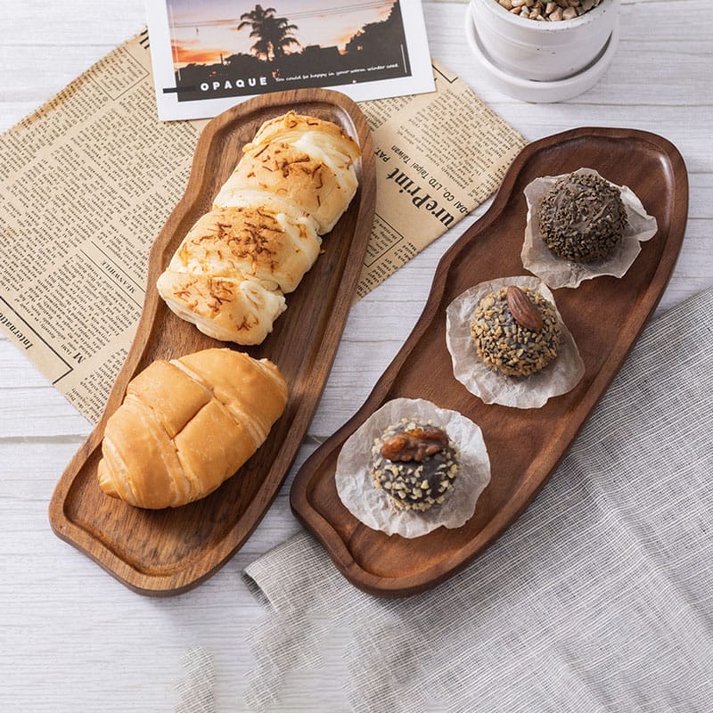 Two acacia wood trays wholesale in cloud shapes, one with pastries and the other with chocolates.