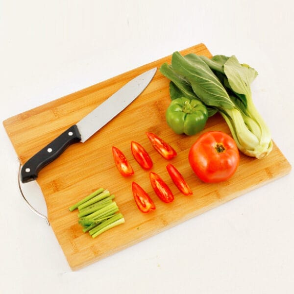 Bamboo cutting board with knife, vegetables, and herbs. Wholesale chopping board.
