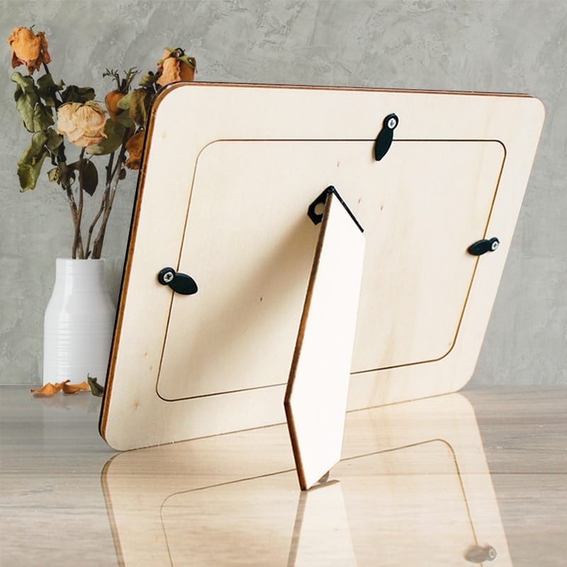 Back view of a blank wood photo frame with flowers in a vase