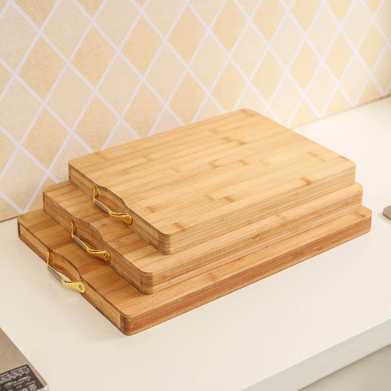 Three stacked custom bamboo cutting board with gold handles. Eco-friendly wholesale option.