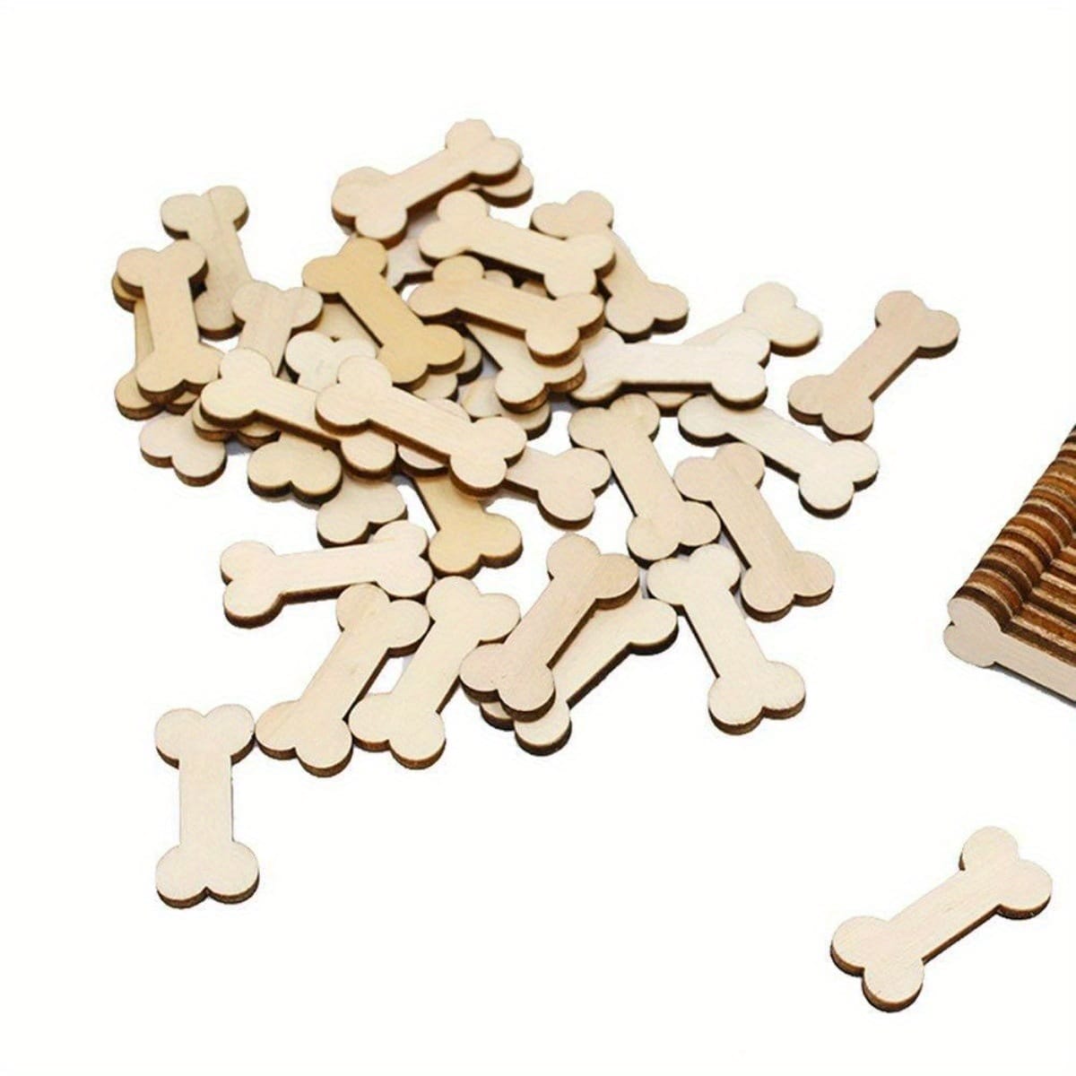 Pile of unfinished wooden dog bone cutouts. Wholesale wooden dog bone shapes.