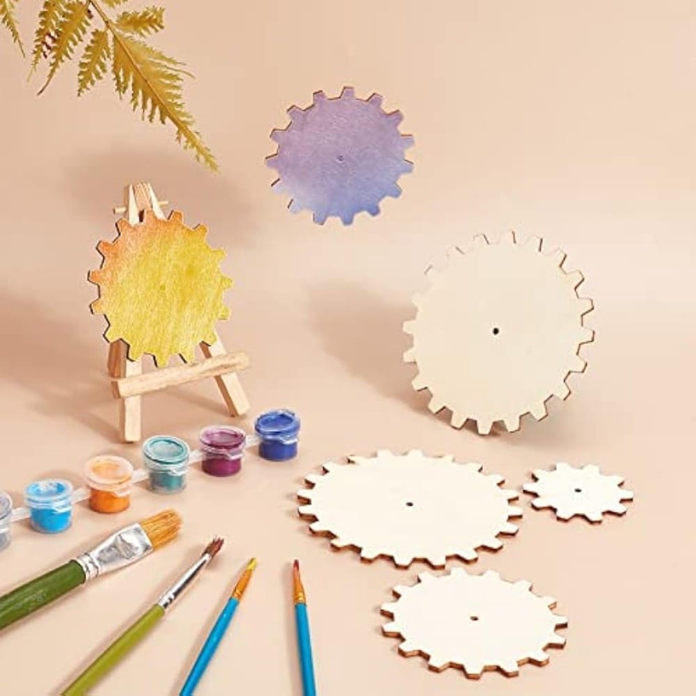Hand-painted wooden gears and a small easel with painted gear, showcasing custom wood cutout manufacturing for decorative use.