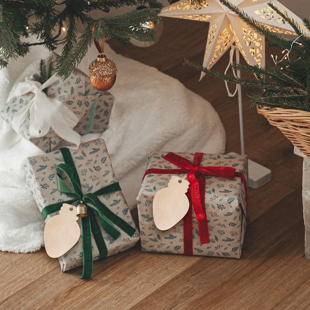 Christmas gifts wrapped in floral paper with unfinished wood ornaments.