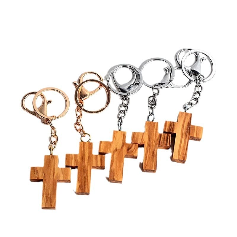 Assorted olive wood cross keychains with gold, silver, and rose gold keyrings. Wholesale supplier of custom wooden keychains.