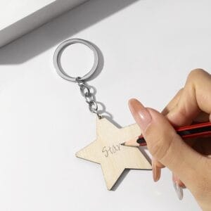 Hand writing "Star" on a custom laser-cut wooden star keychain. Wholesale supplier of wooden keychains.