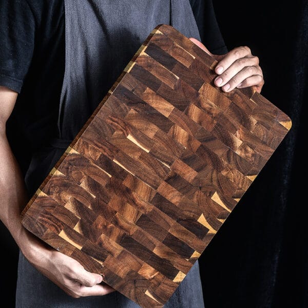 Person holding large, double-sided, factory custom end grain cutting board.