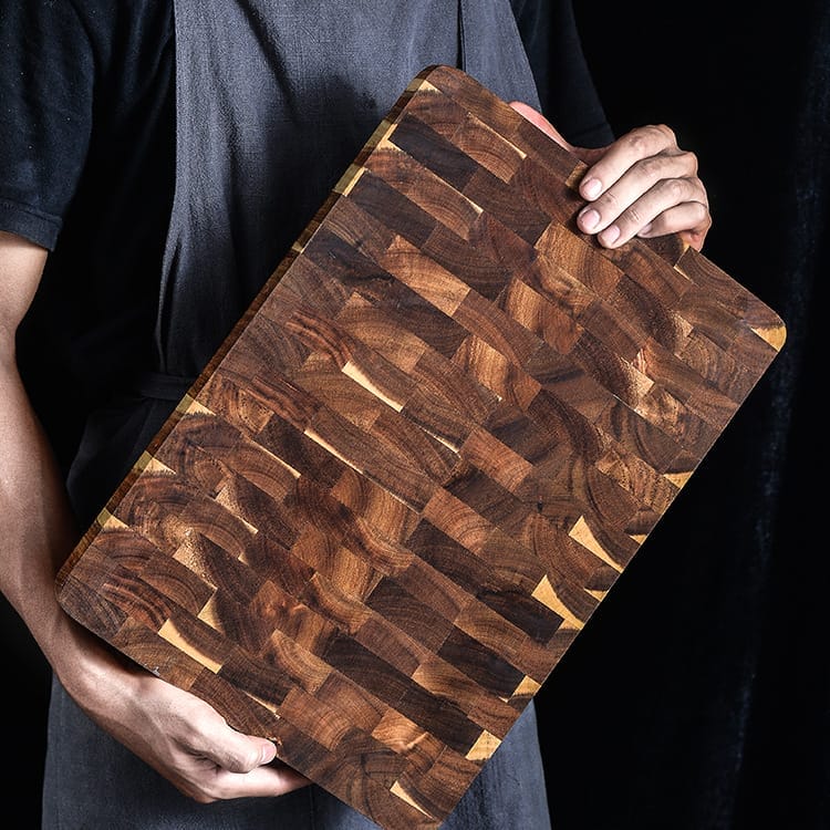 Person holding large, double-sided, factory custom end grain cutting board.
