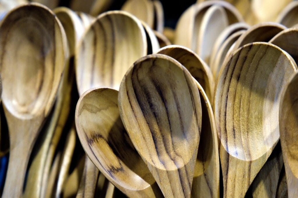 Close-up of a pile of wooden spoons, showcasing their natural grain and texture.