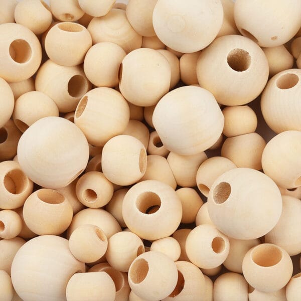 Close-up of numerous unfinished, natural wooden beads, ideal for DIY jewelry making.