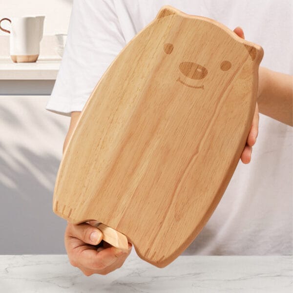 Person holding a cute bear-shaped oak chopping board. Wholesale supplier of quality chopping boards.