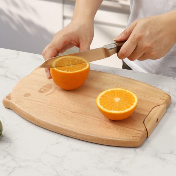 Person slicing oranges on a light brown oak wood chopping board. Wholesale cutting boards available.