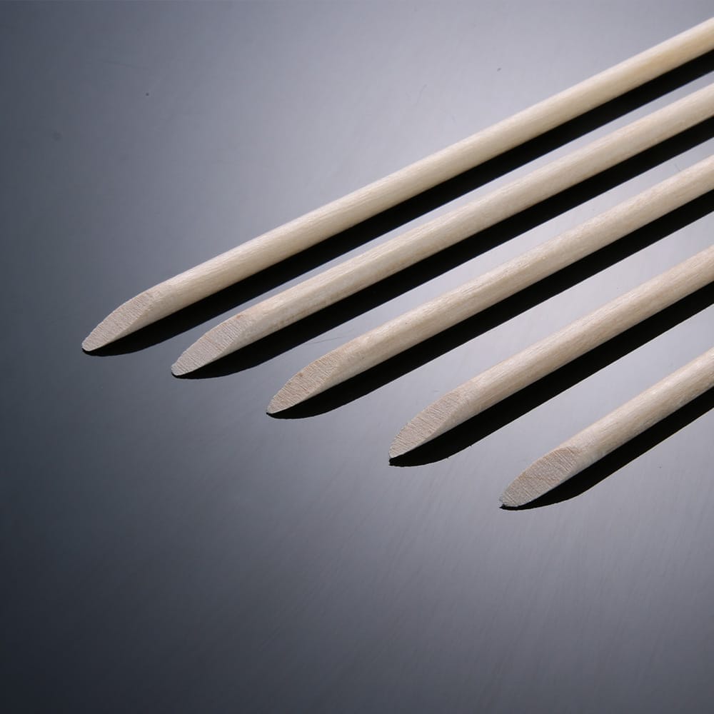 Set of four professional orange wood cuticle pushers for manicure and pedicure. Ideal for nail care.