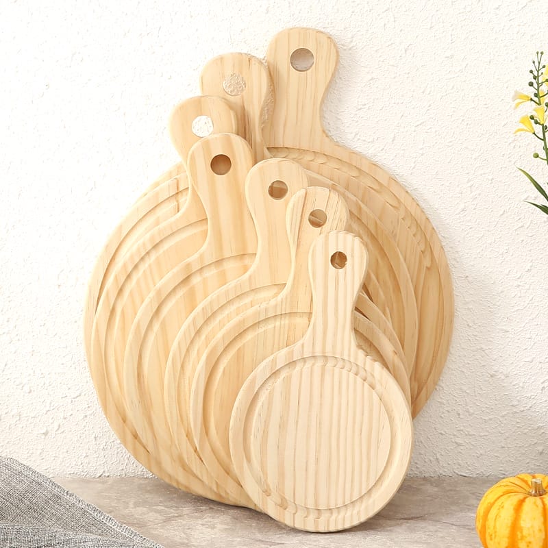 Stacked round pine wood pizza boards with handles, perfect for restaurants. Wholesale supplier of pine wood trays.