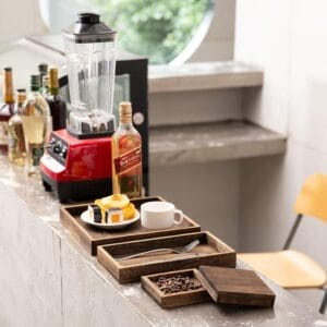 Rectangular wooden trays, coffee, and a blender on a counter. Eco-friendly wood trays for wholesale.