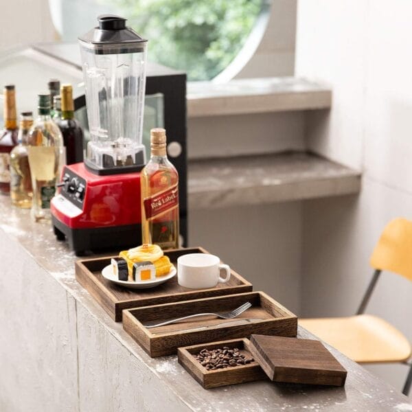 Rectangular wooden trays, coffee, and a blender on a counter. Eco-friendly wood trays for wholesale.