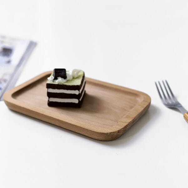 Rectangular beech wood tray holding a small cake. Ideal for wholesale.