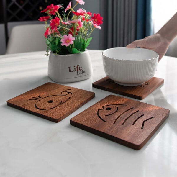 Set of three square solid wood coasters featuring carved fish and crab designs. Perfect for tea, coffee, or drinks.