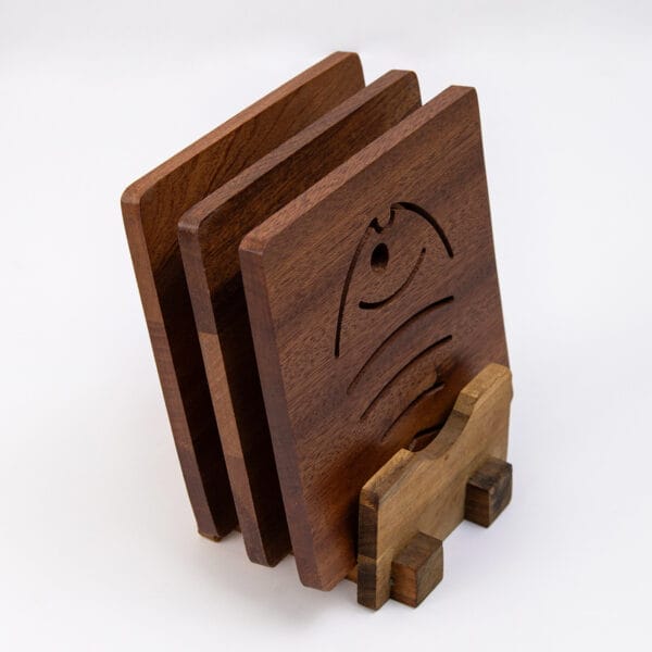 Set of square wooden coasters with decorative cutouts, displayed on a matching stand. Perfect for tea or drinks.