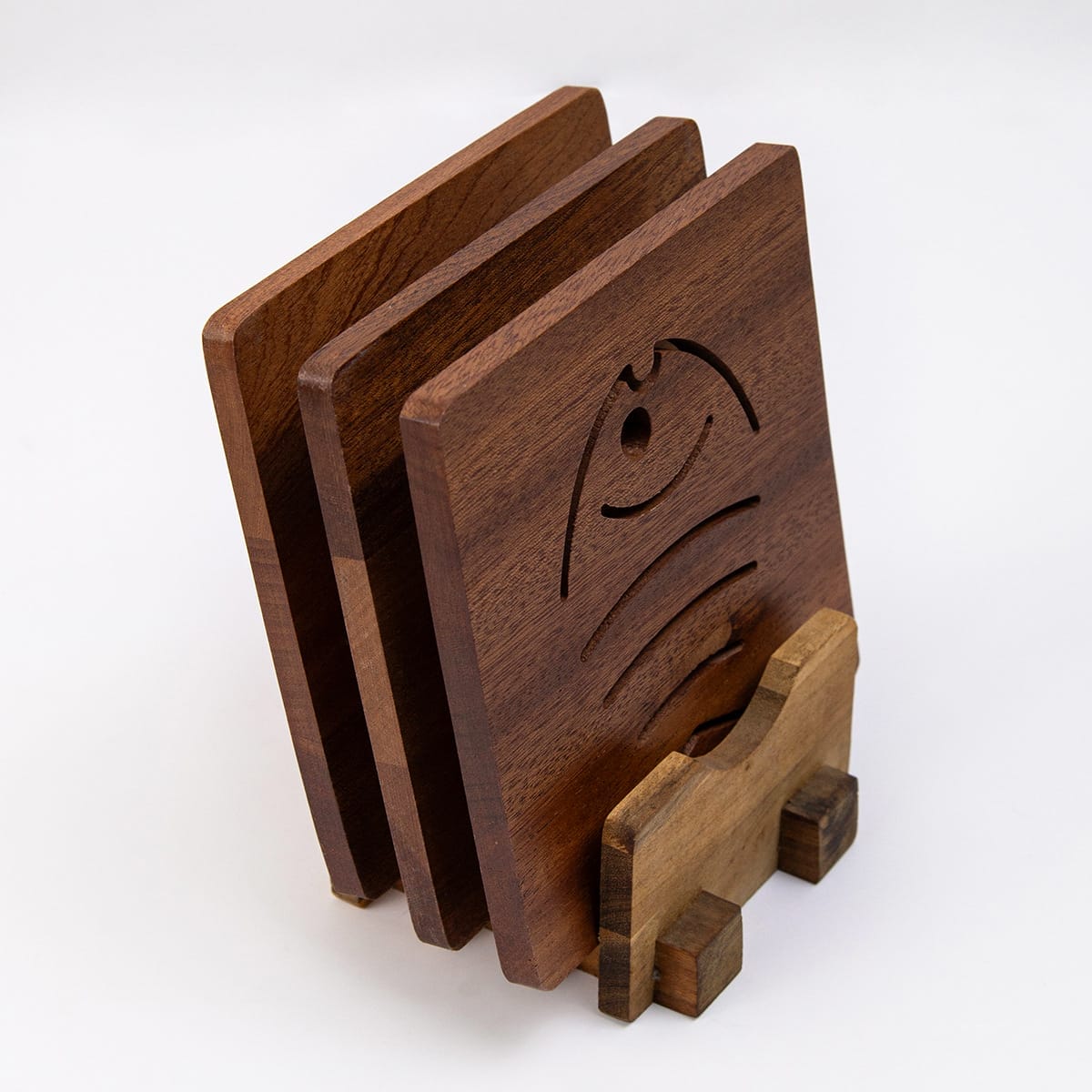 Set of square wooden coasters with decorative cutouts, displayed on a matching stand. Perfect for tea or drinks.