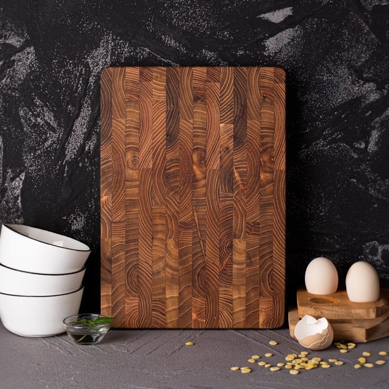 Rustic teak wooden cutting board, eggs, and bowls. Wholesale cutting boards.