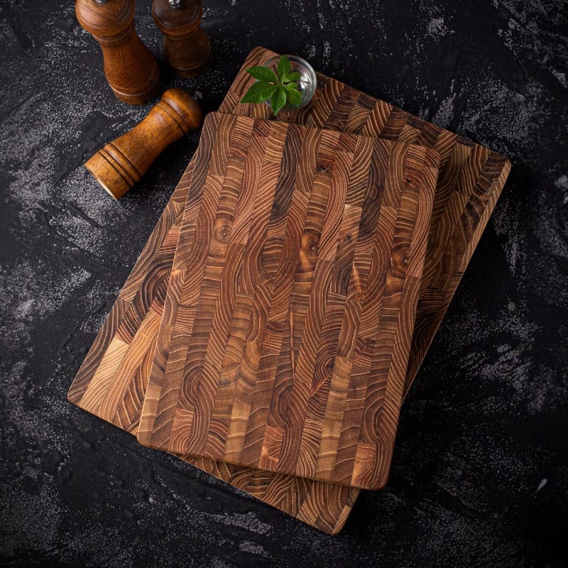 Two richly-grained teak wooden cutting boards, ideal for wholesale. Supplier of high-quality cutting boards.