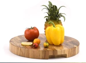 Round teak end grain cutting board, large, with fruits and vegetables