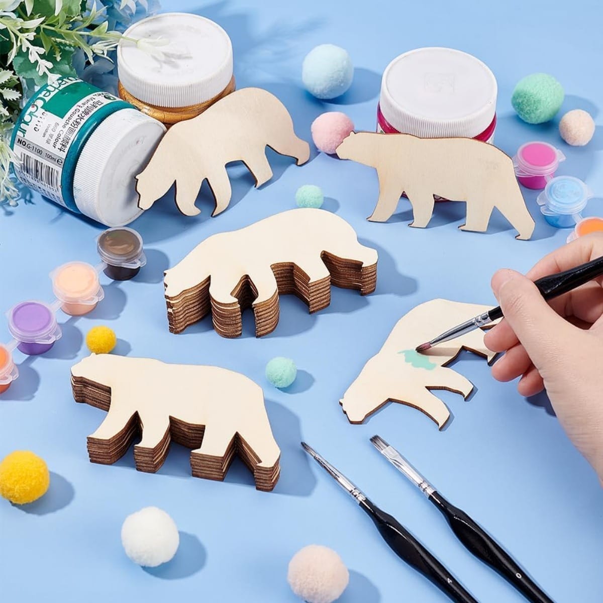 Unfinished wooden bear shapes and paint supplies for craft projects. Wholesale wooden pendants available.