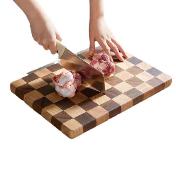 Hands using a knife to cut meat on a walnut checkerboard cutting board. Wholesale kitchen boards.