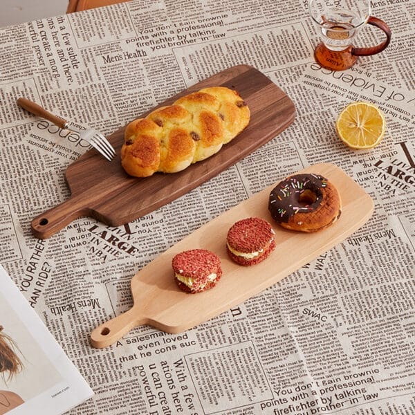 Acacia wood cutting boards with bread and pastries. Wholesale supplier for distributors.