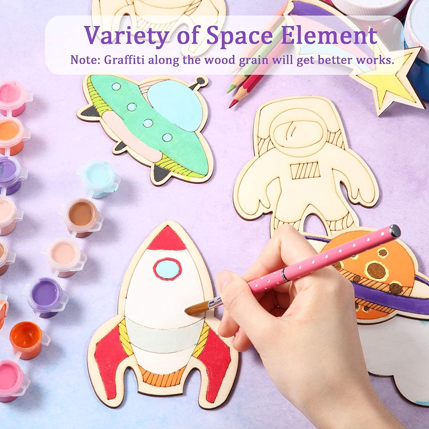 Unfinished wooden space-themed cutouts with paint and brushes. Great for DIY crafts and wholesale.