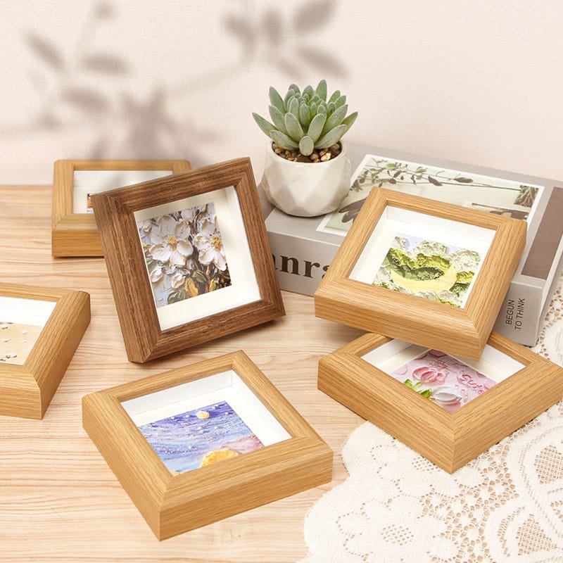 Mini square wooden picture frames in natural wood tones, showcasing various artwork. Wholesale wood picture frames available.