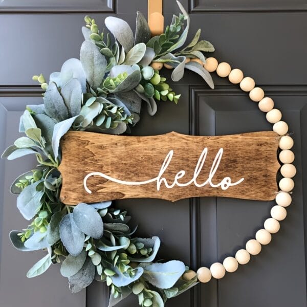 Wood bead wreath with greenery and "hello" sign. Supplier of wooden bead door hangings.