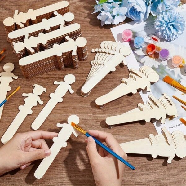 Hands painting wooden cutout people shapes. Wholesale wooden craft supplies.