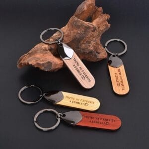 Three wooden keychains engraved "You're my favorite asshole". Wholesale wooden keychain supplier.